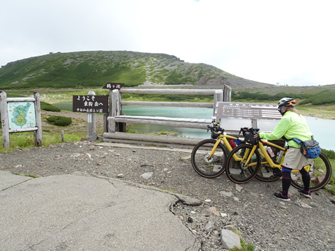 畳平にある鶴ケ池の前で